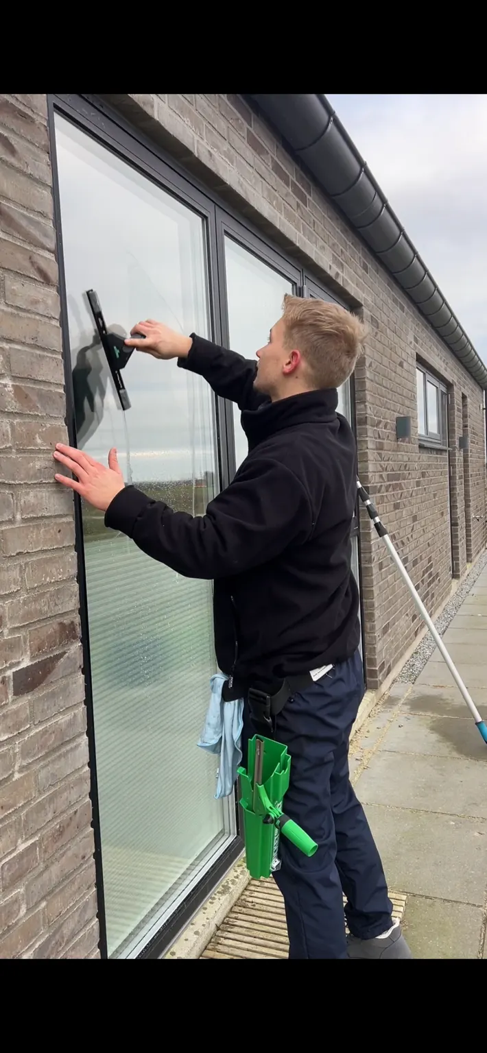 Vinduespudser i arbejde på parcelhus i Hedensted